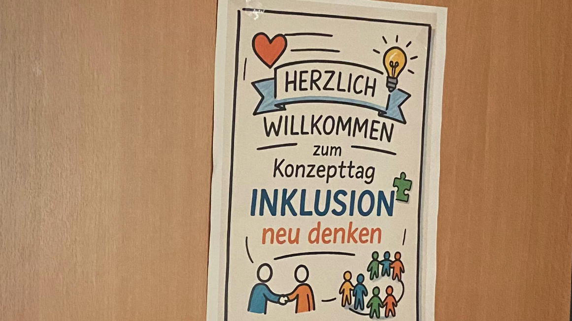 Auf dem Foto ist ein Plakat zu sehen, das an einer Tür oder Wand hängt. ?️ Was das Plakat sagt: Titel: HERZLICH WILLKOMMEN zum Konzepttag INKLUSION Untertitel: neu denken Bildelemente: Ein rotes Herz. Eine leuchtende Glühbirne (Symbol für eine neue Idee). Eine Sprechblase oder ein Banner mit der Aufschrift "HERZLICH WILLKOMMEN". Ein Puzzleteil (neben "INKLUSION"). Zwei Personen, die sich die Hand geben (symbolisiert Verbindung oder Zusammenarbeit). Eine Gruppe verschiedener, farbiger Strichmännchen (steht für Vielfalt und Gemeinschaft). Zusammenfassend: Es handelt sich um eine Einladung zu einem Konzepttag zum Thema Inklusion mit dem Motto, dieses Thema "neu zu denken". Sieht nach einem Tag voller Ideen aus – hoffentlich mit gutem Kaffee!
